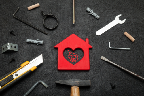 Rotes Holzhaus-Symbol mit Werkzeugen – nachhaltige Dachsanierungskonzepte von SVB-K